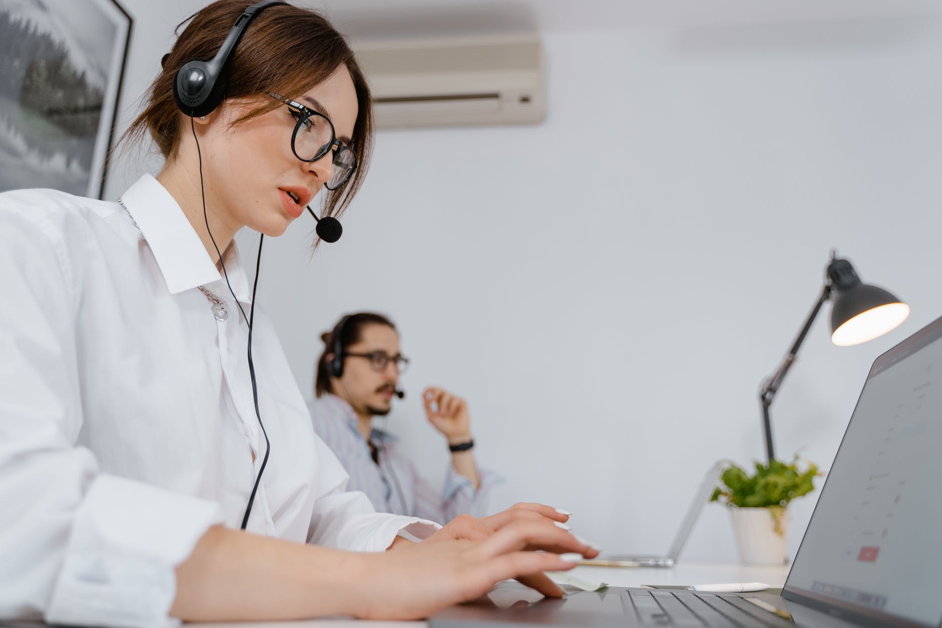 a call center agent typing on the laptop